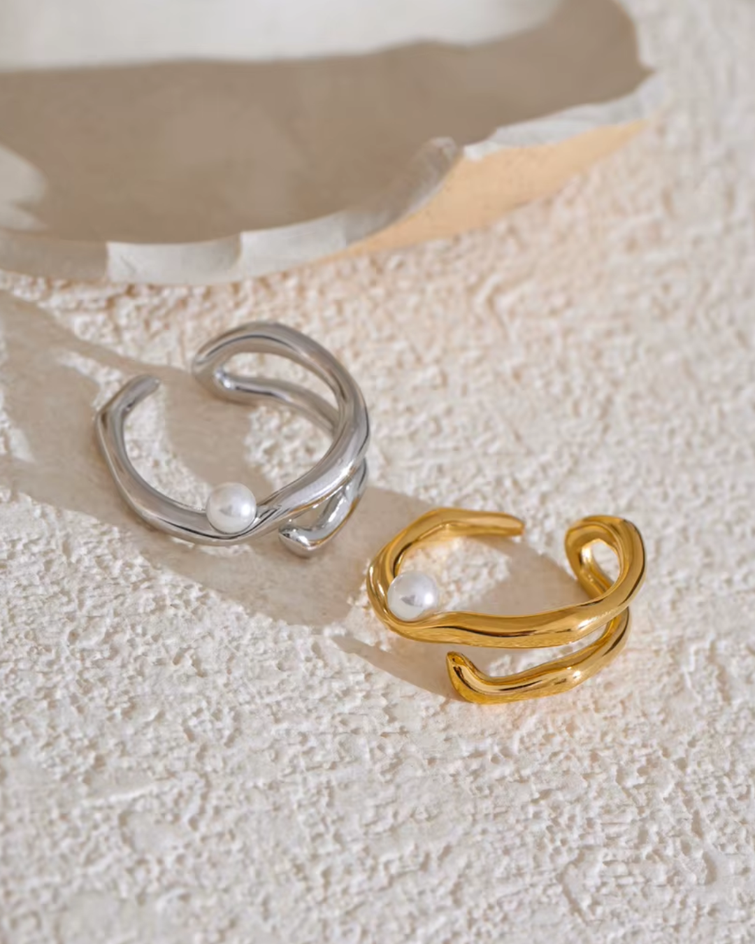 A sleek, open ring made from high-quality stainless steel, featuring pearl accents within a modern geometric design. Its minimalist, chic style adds sophistication to any outfit, ideal for everyday wear or special occasions.