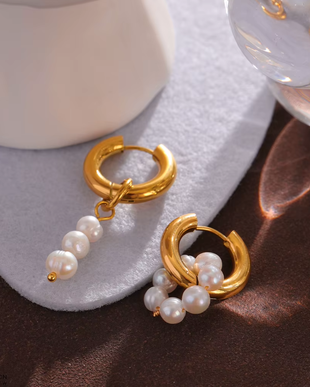 Gold hoop earrings with detachable freshwater pearls in an asymmetrical design. Elegant and versatile.