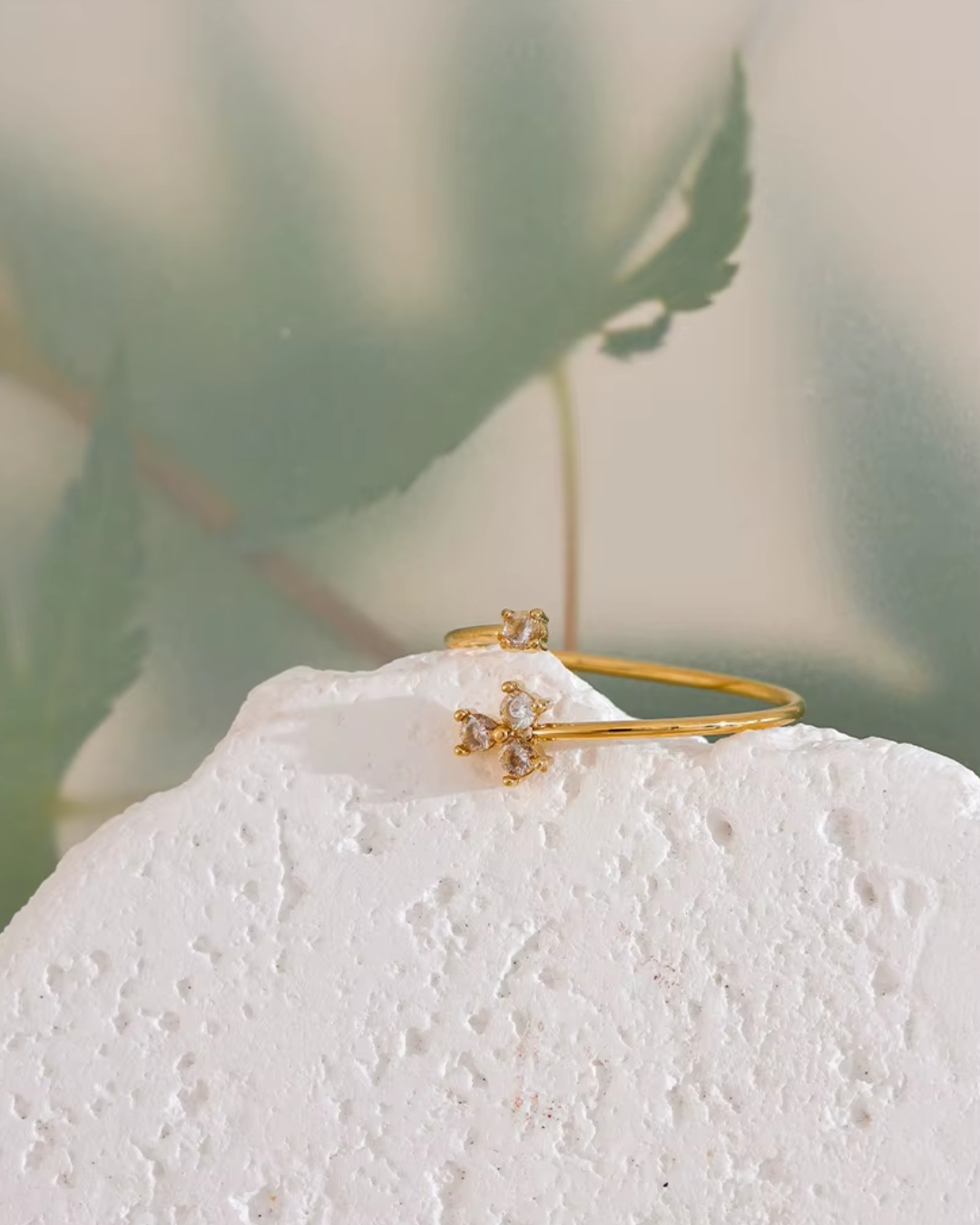 A delicate golden ring featuring a cubic zirconia flower on a thin, adjustable band. Crafted from durable stainless steel with a waterproof finish, this elegant and chic ring adds a touch of luxury to any outfit. Perfect for everyday wear or as a timeless gift.