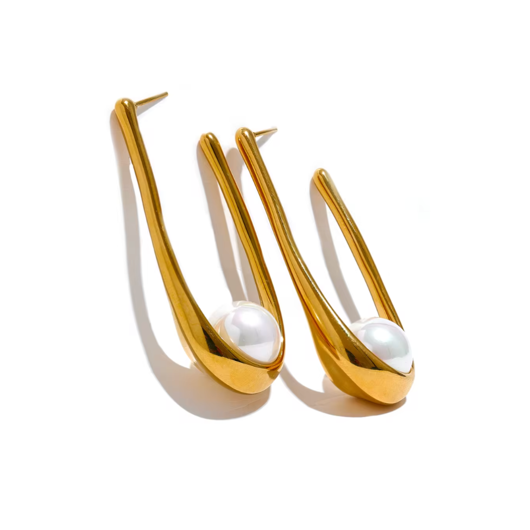 Elegant geometric huggie earrings featuring luminous pearls in gold or silver. Hypoallergenic and tarnish-resistant, perfect for effortless sophistication.