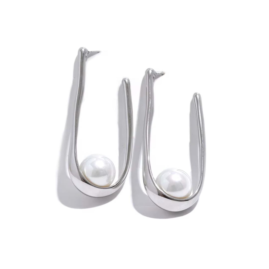 Elegant geometric huggie earrings featuring luminous pearls in gold or silver. Hypoallergenic and tarnish-resistant, perfect for effortless sophistication.